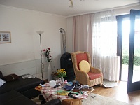 PICT2904  Huiskamer. Links een slaapbank, rechts kachel met stoel